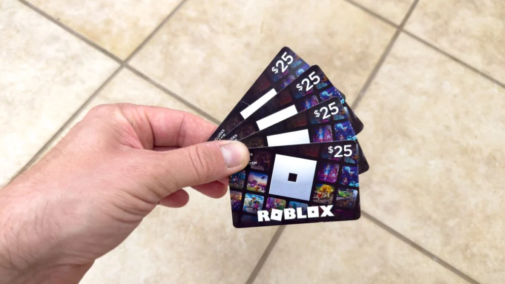 Hand holding plastic vouchers - Roblox gift card redeem